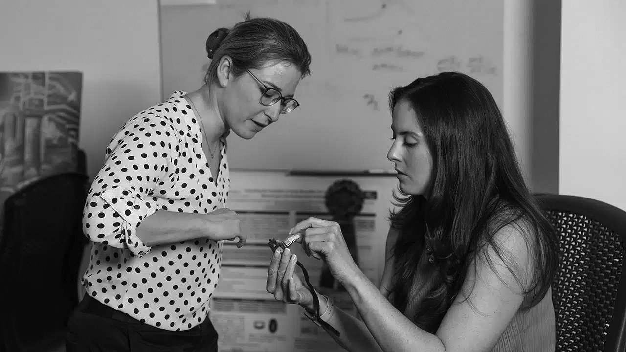 Lauren Lederer and Jessilyn Dunn examining a wearable sensor in the BIG IDEAs Lab